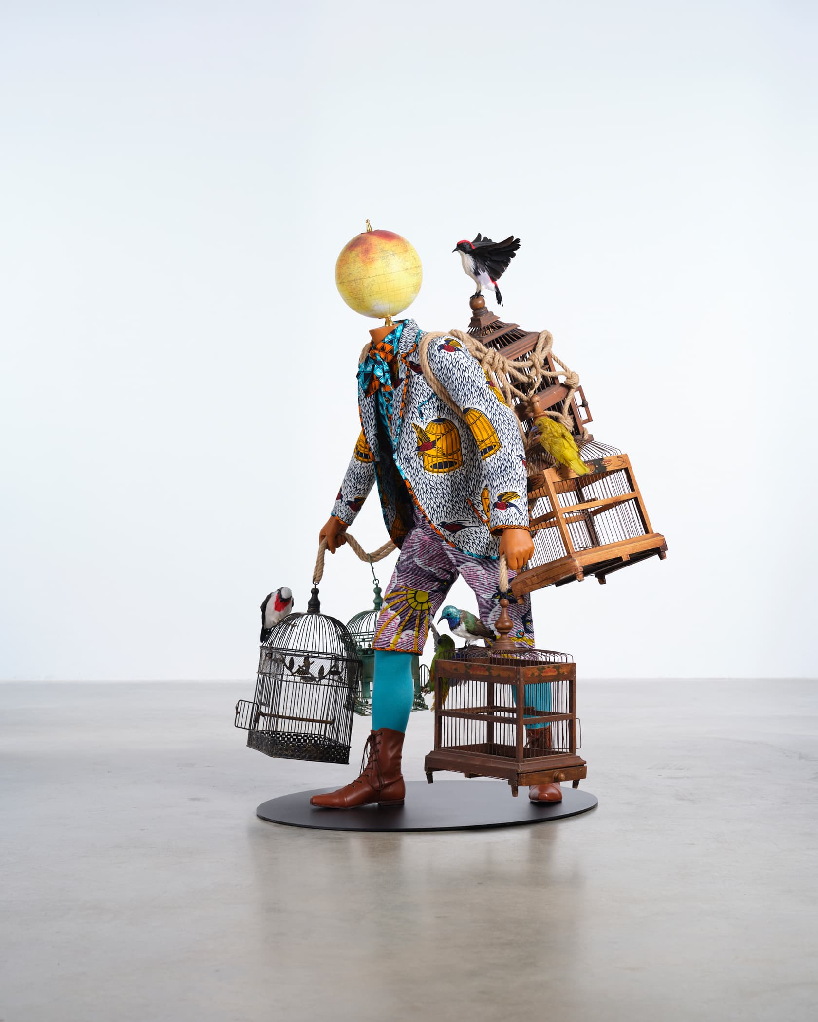 Sculpture of a man holding several birdcages