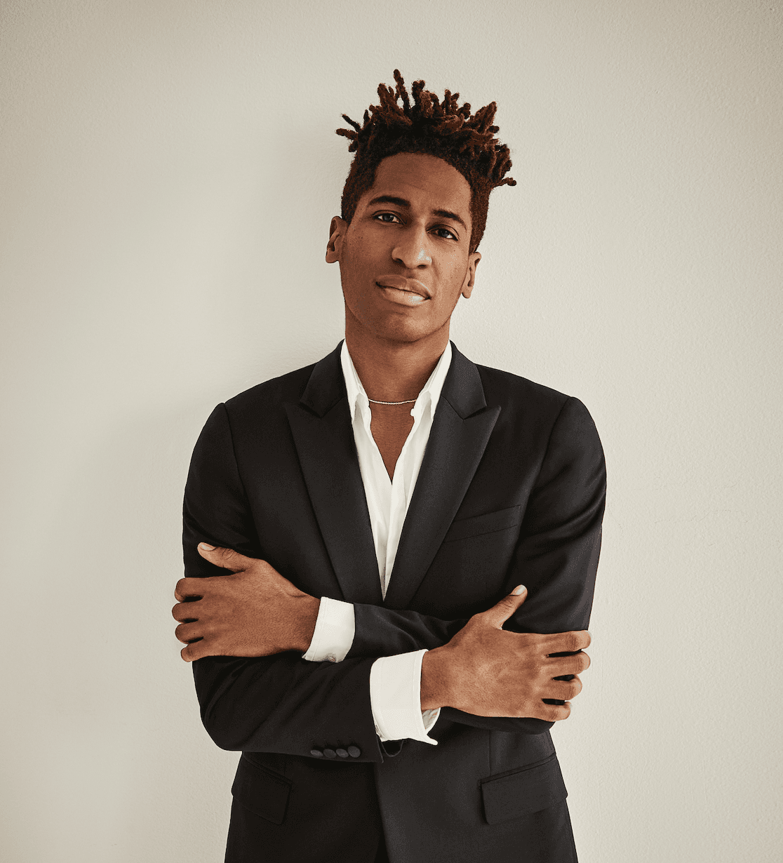 Jon Batiste posing in a suit