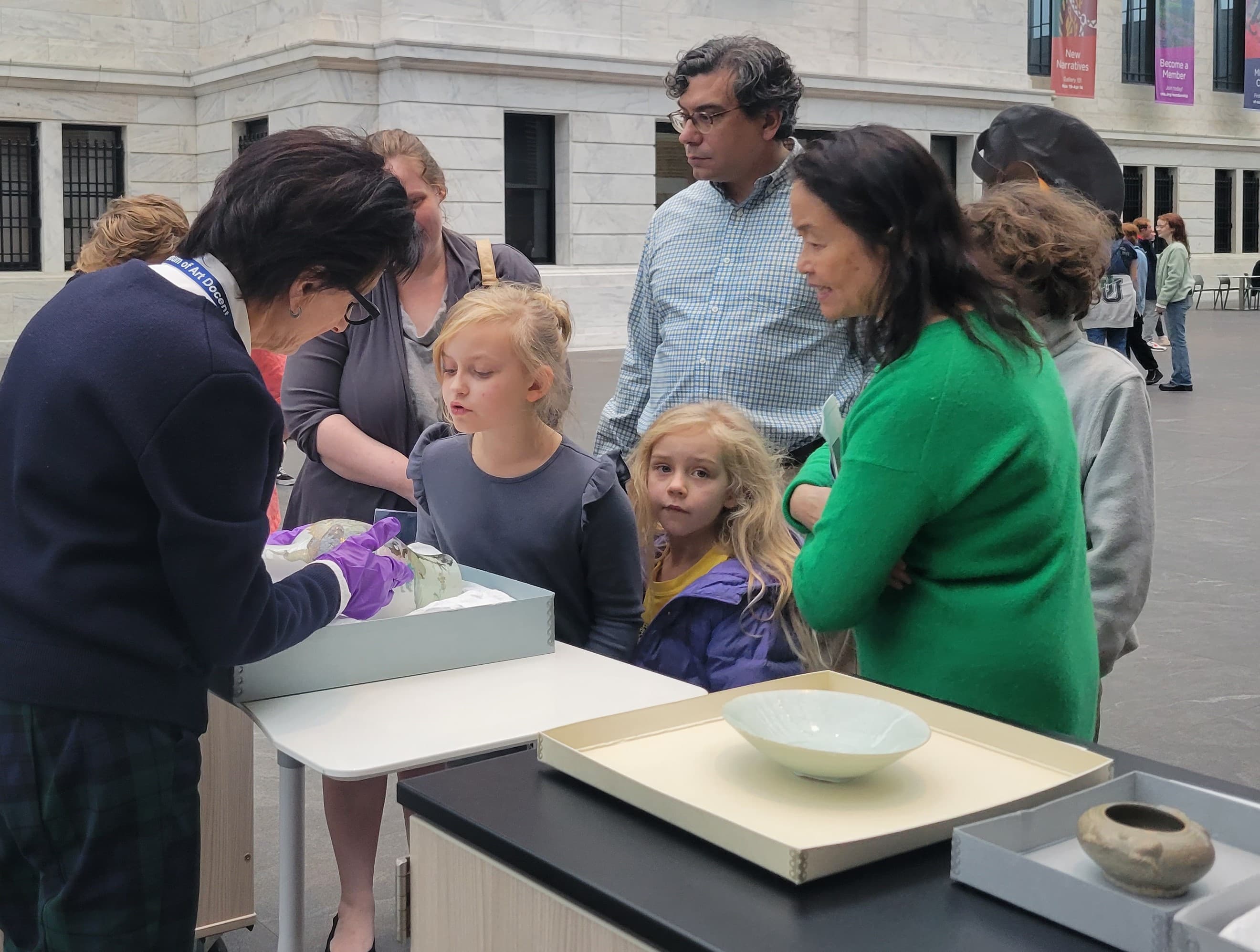 a family looking at a selection of objects from the Education Art Collection