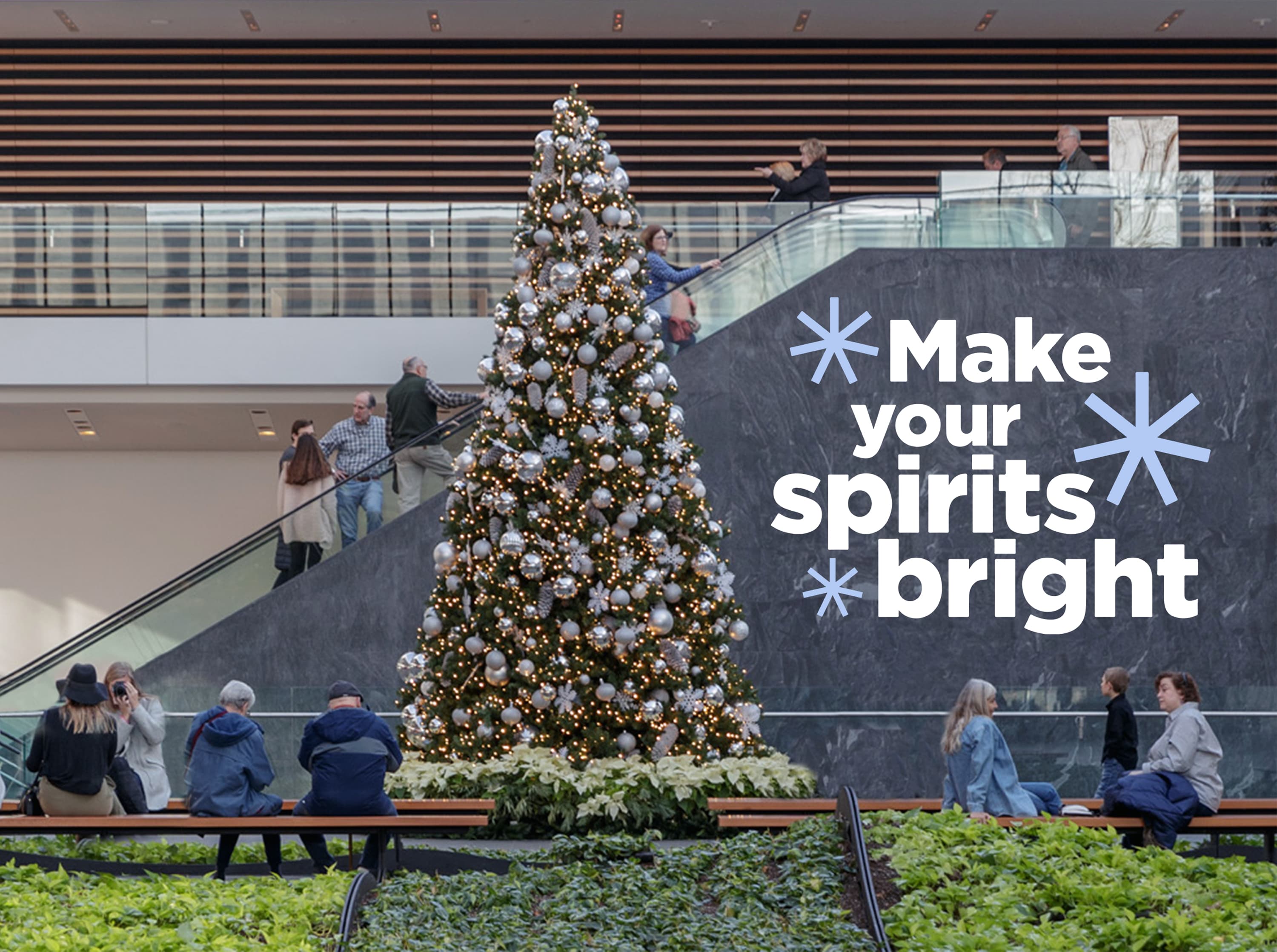 Holiday tree in the atrium with text overlay that says "Make your spirits bright"