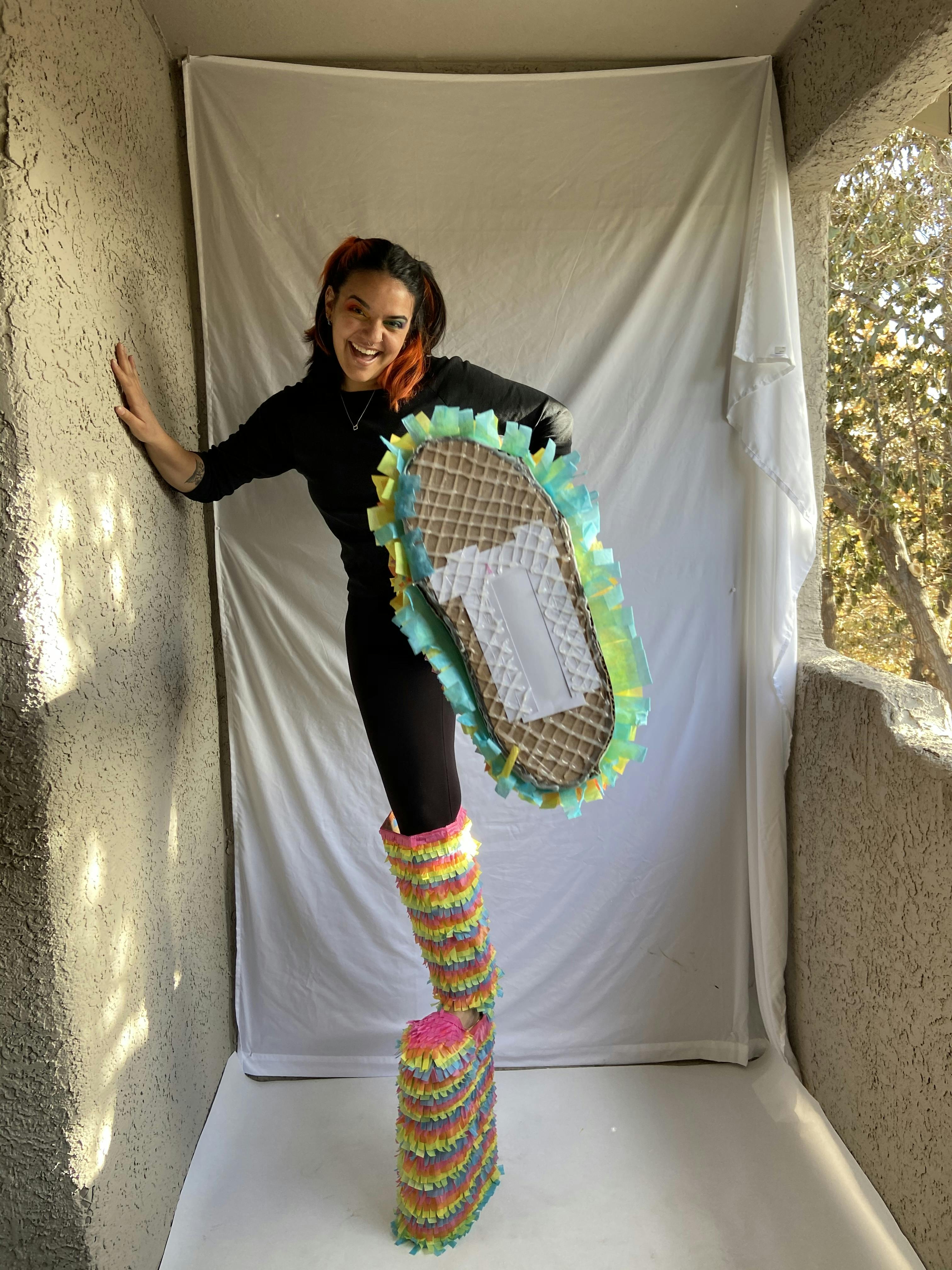 Artist wearing shoes made from piñata materials.