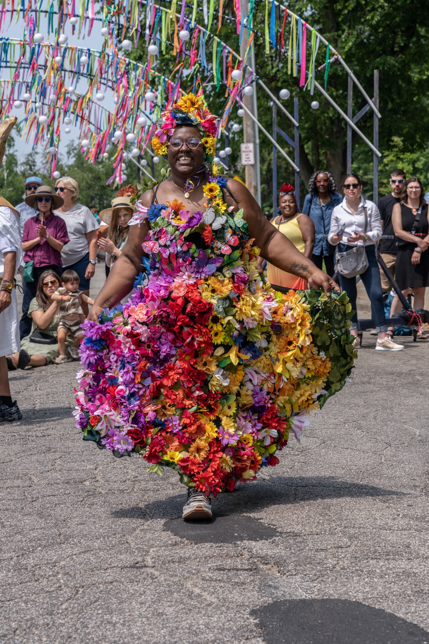 Woman in dress made of flowers walking in a parade