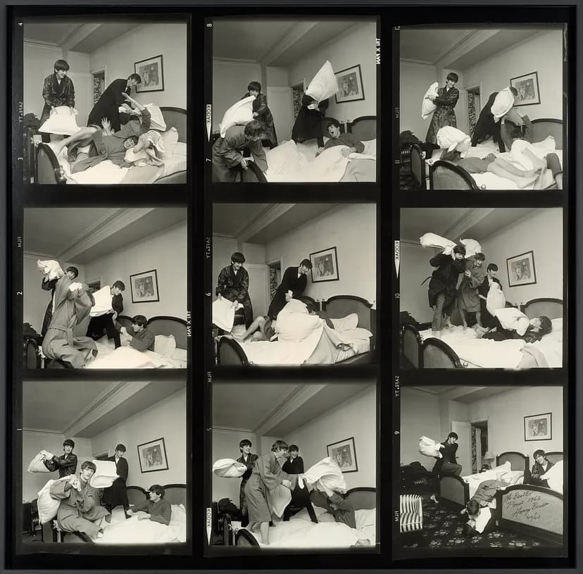 A grid of nine images of four men pillow fighting on a bed.