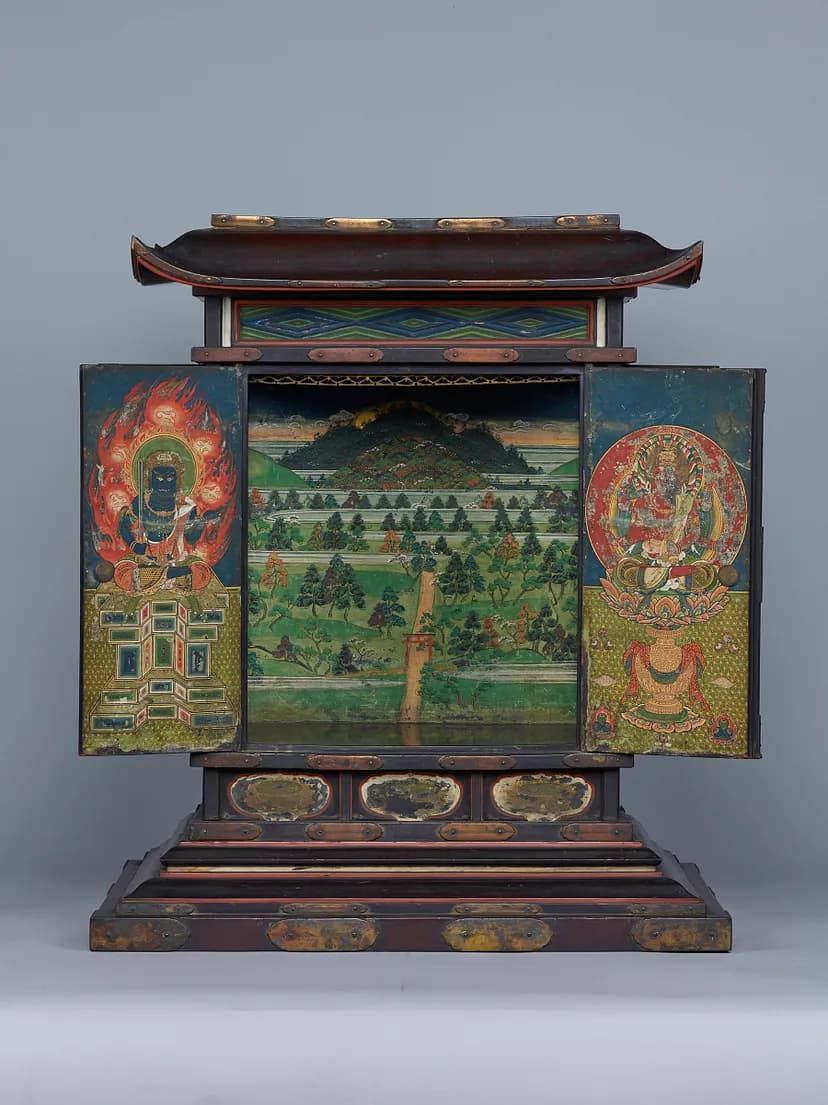 A shrine with doors open to reveal a scene with rows of trees and greenery and mountains in the background. On the inside of the left door is a blue figure seated on a geometric pedestal, on the right door a chipped away red figure seated on a lotus.