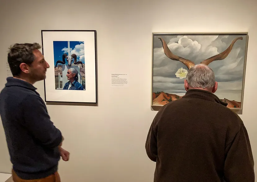 Two people looking at art on the wall.