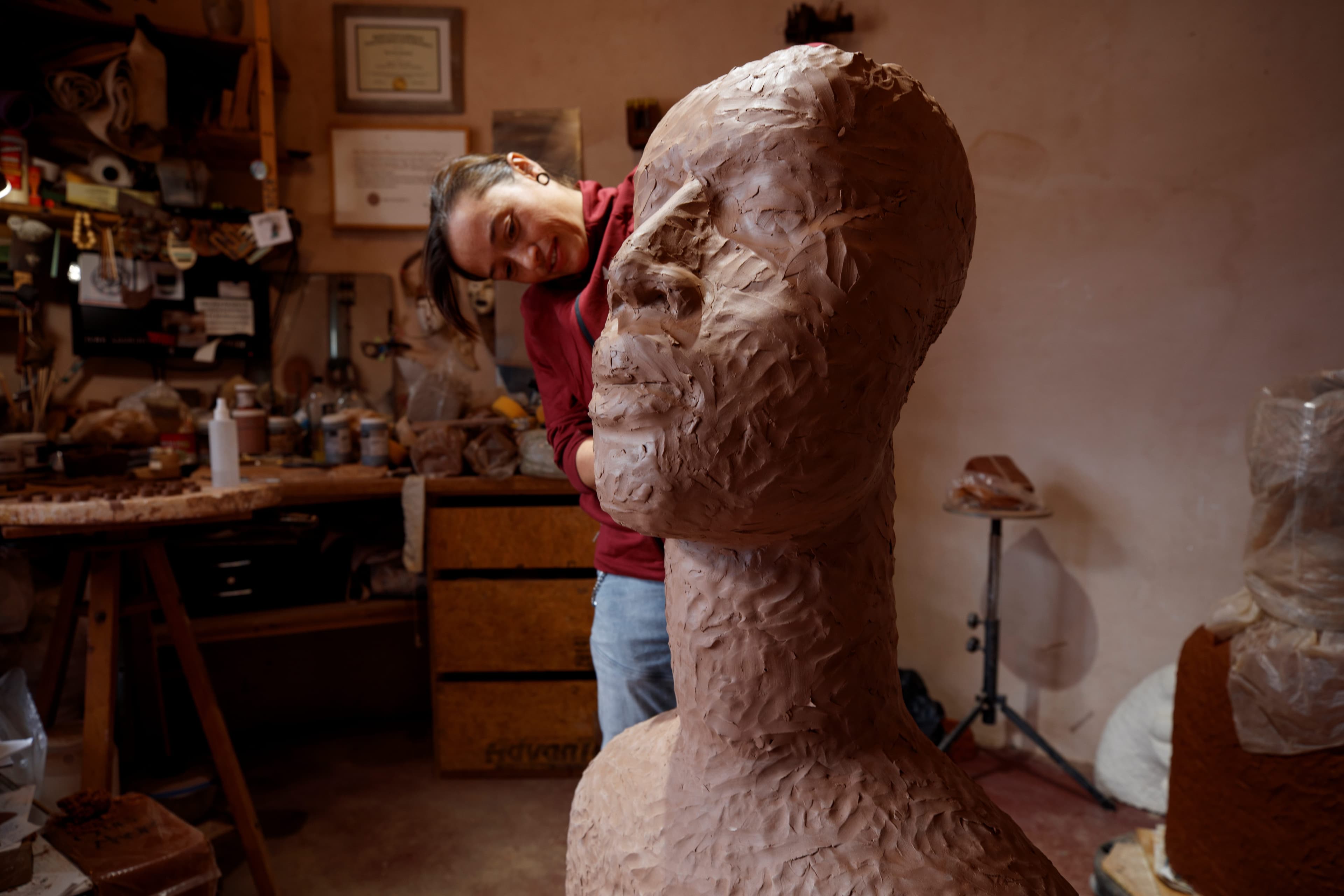 Rose B. Simpson sculpting clay into a bust of a head