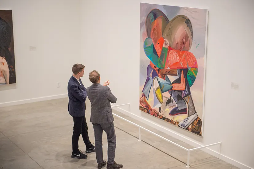 Two visitors looking at a painting in the Dana Schutz’s Eating Atom Bombs exhibition.