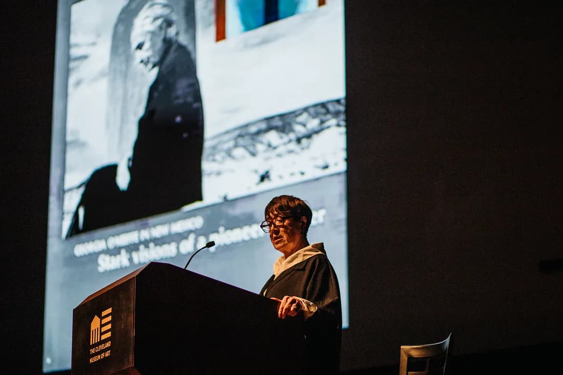 Person at a podium with the Georgia O'Keeffe LIFE Magazine cover on the screen behind them.