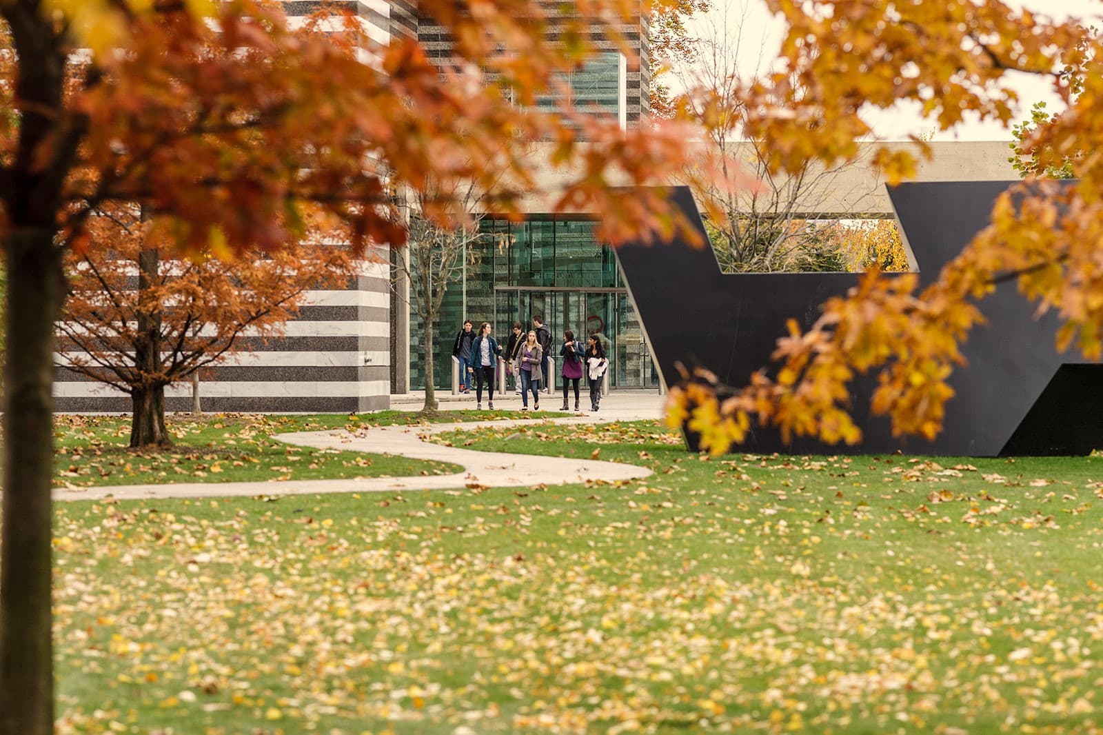 Group of people leaving the museum with fall foliage around them
