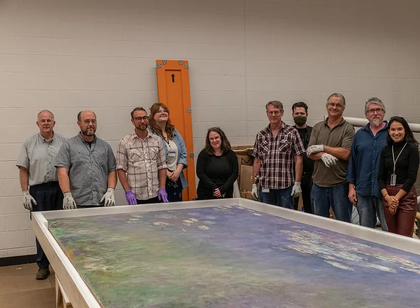 10 people standing behind Claude Monet's Waterlilies painting, laid out flat in front of them.