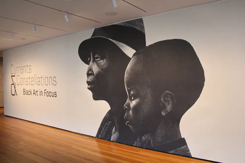 Currents & Constellations: Black Art in Focus exhibition image with the name of the show and two people staring off to the left covering the wall from the neck up.
