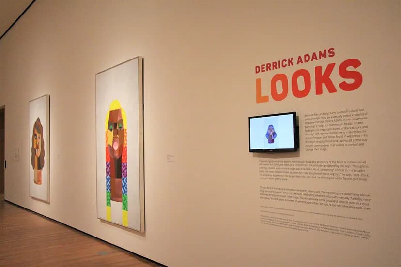 Exhibition image of Derrick Adams: LOOKS showing wall text and two artworks.