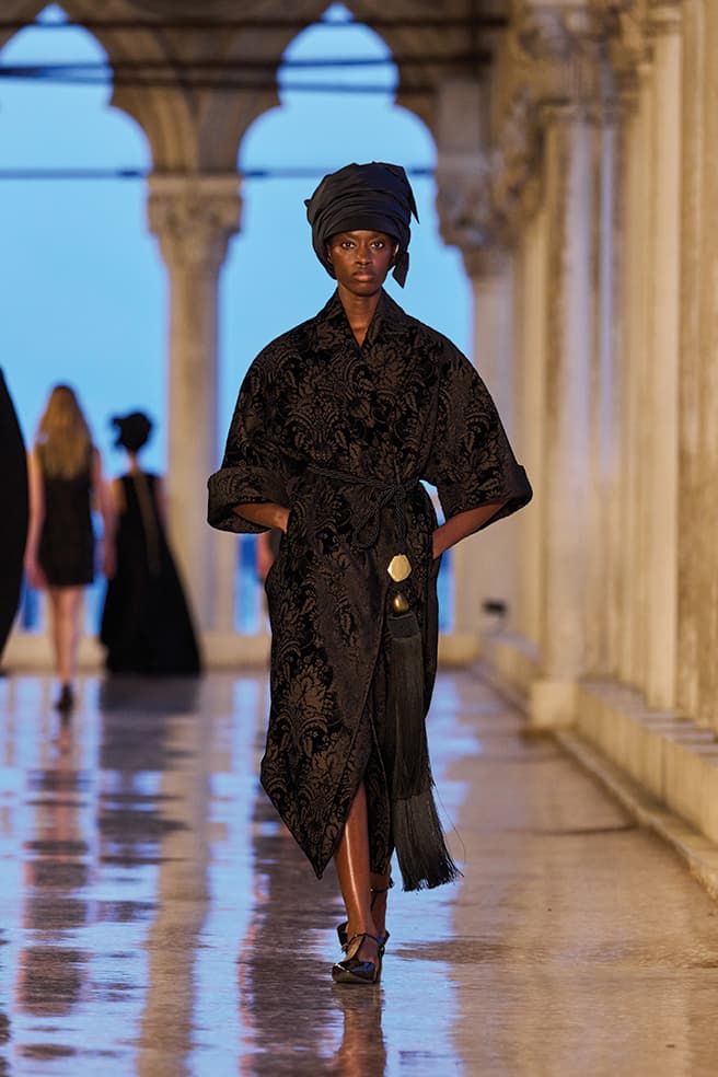 woman walking runway in black robe
