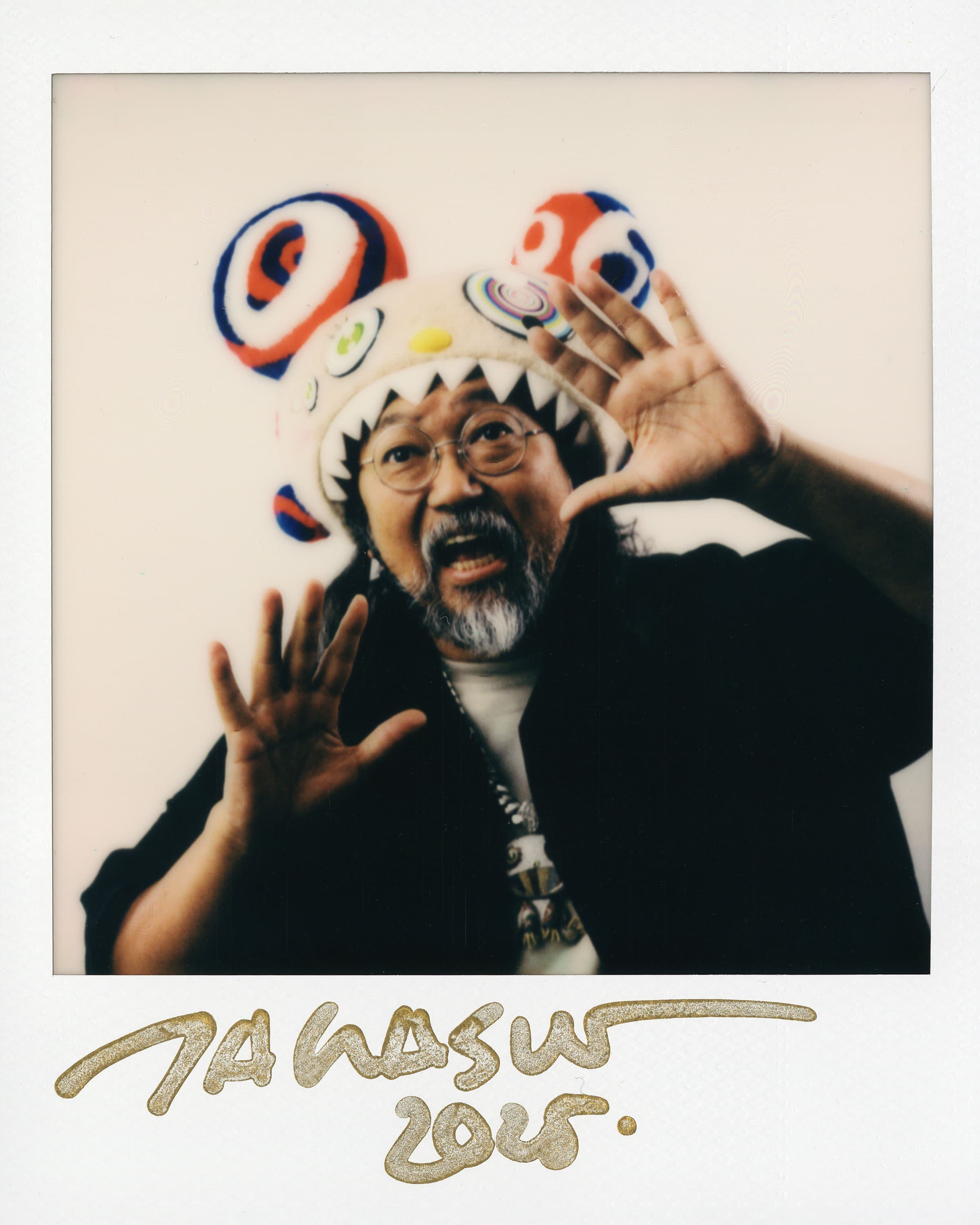 Polaroid of Takashi Murakami with his hands up towards the camera
