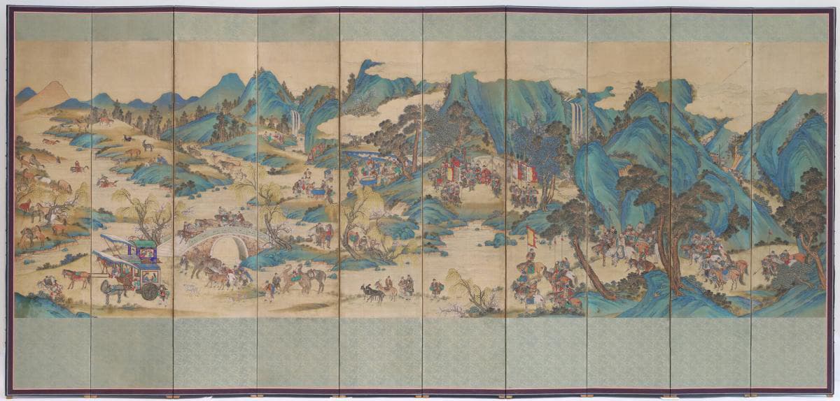 A ten panel folding screen depicting a landscape composed of blue and green mountains. Groups of people walk across the flat parts of the terrain, through the dispersed trees.