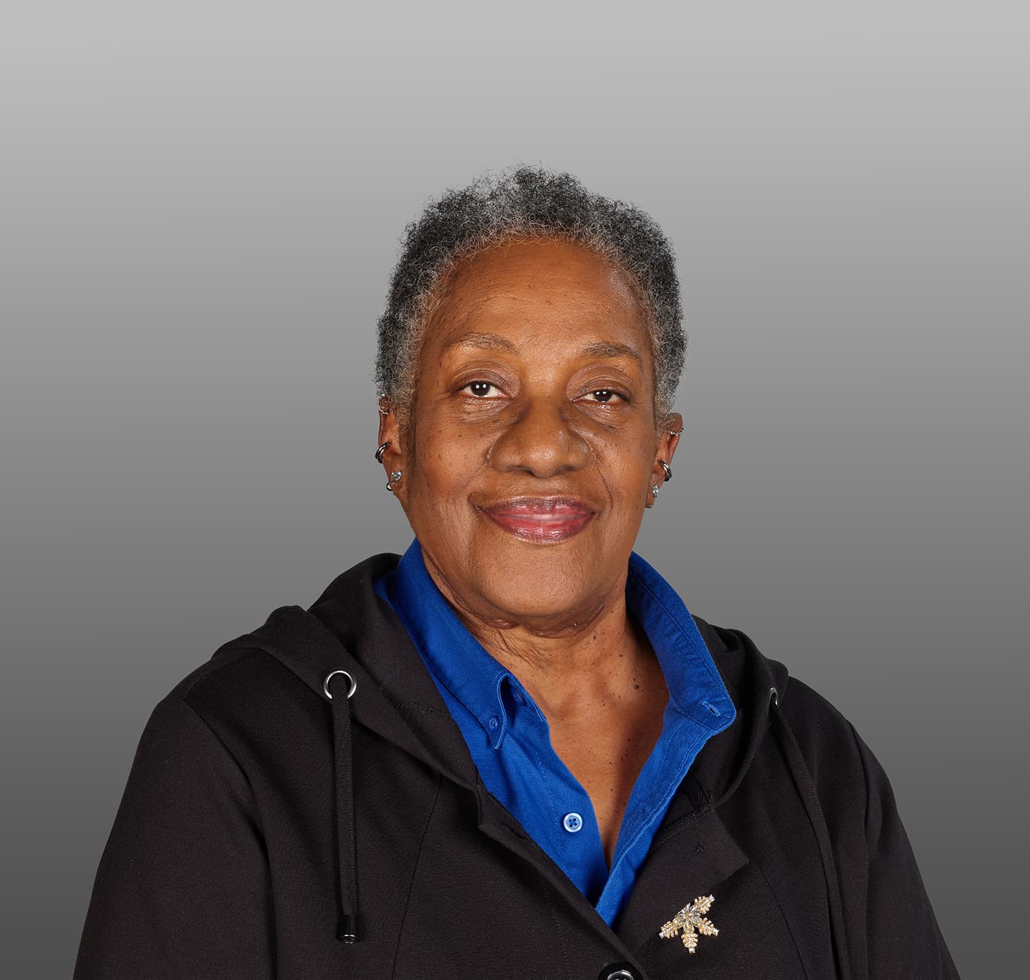 Headshot of a woman with gray hair and a black jacket on