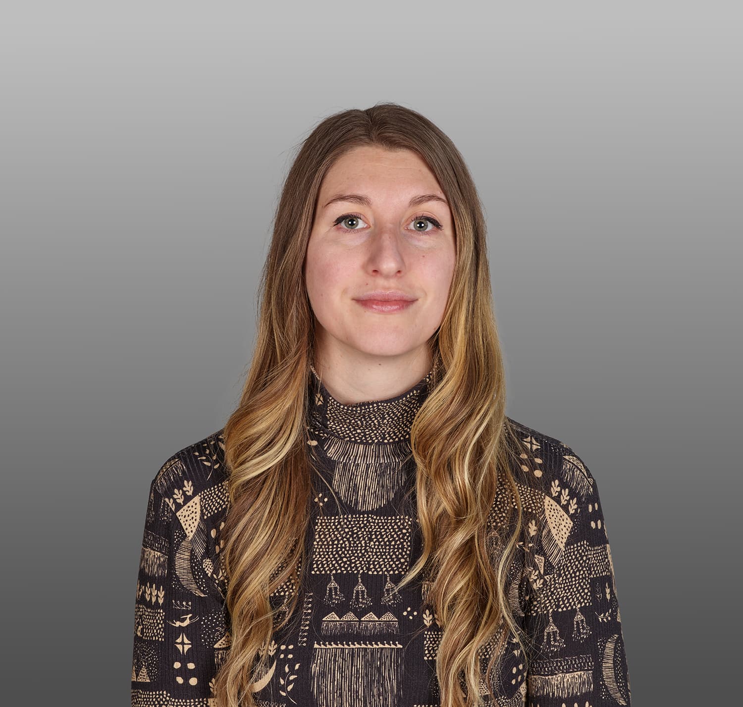 Headshot of a woman with long blonde hair and a patterned shirt
