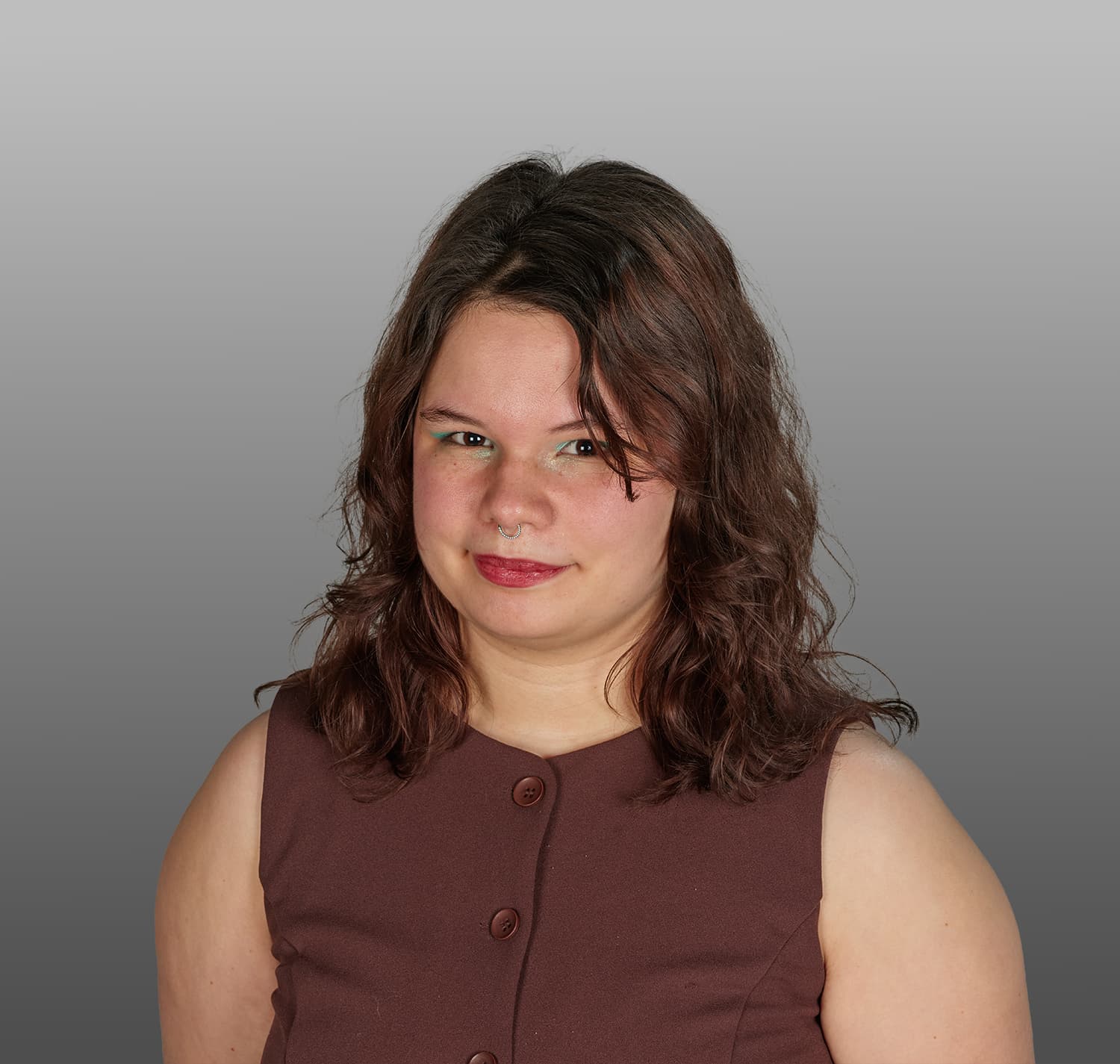 Photo of a woman with brown hair and a brown shirt