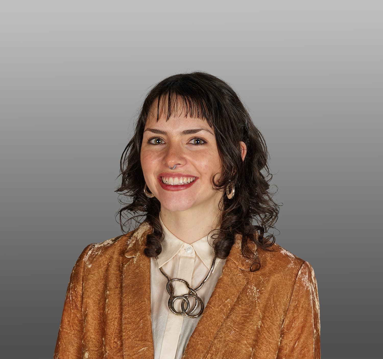 Woman with dark hair and a brown jacket