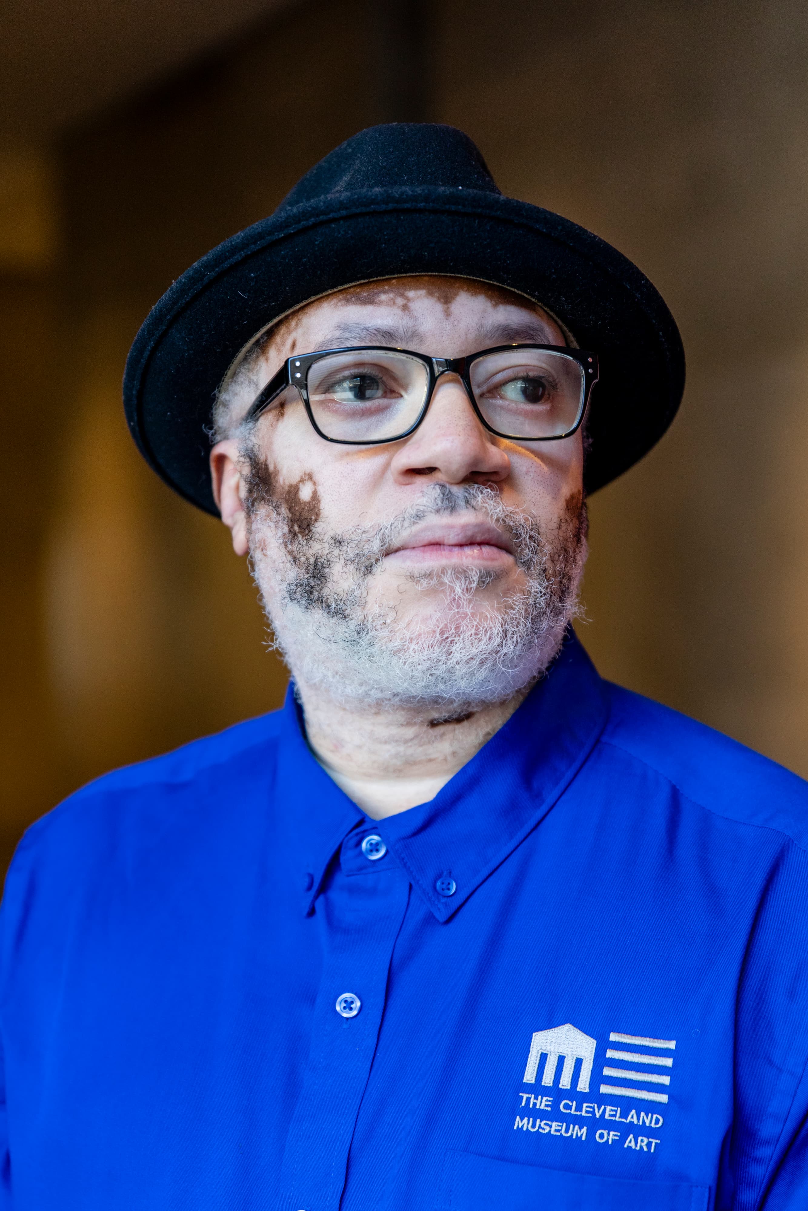 Portrait of a man with a blue polo shirt and a black hat