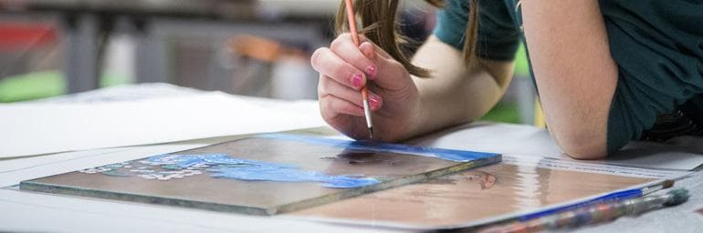A child works on a painting.