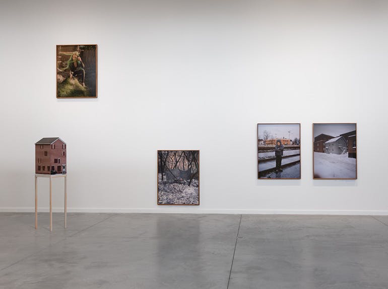 A photo of contemporary artworks on the walls and floor of a gallery  