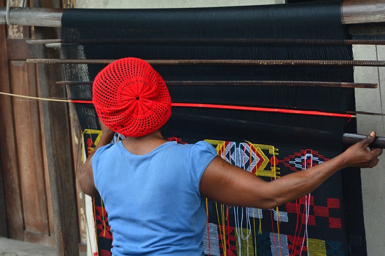 A woman creating Akwétè cloth