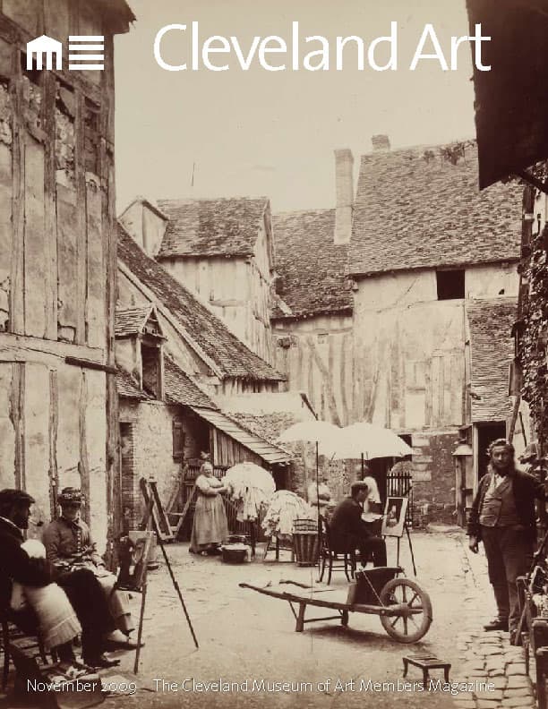 magazine cover with black and white photo of old french village, courtyard with painters and a wheelbarrow